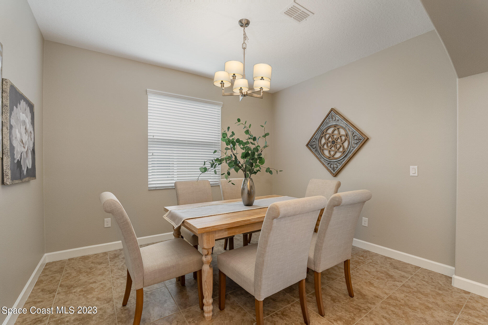 3545 Sansome Circle Melbourne, FL 32940 - Photo 6 of 27 a dining room with furniture a chandelier and wooden floor