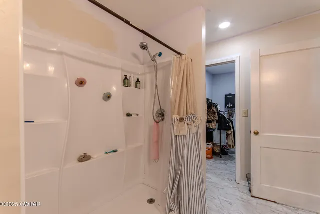a bathroom with a shower and a glass door