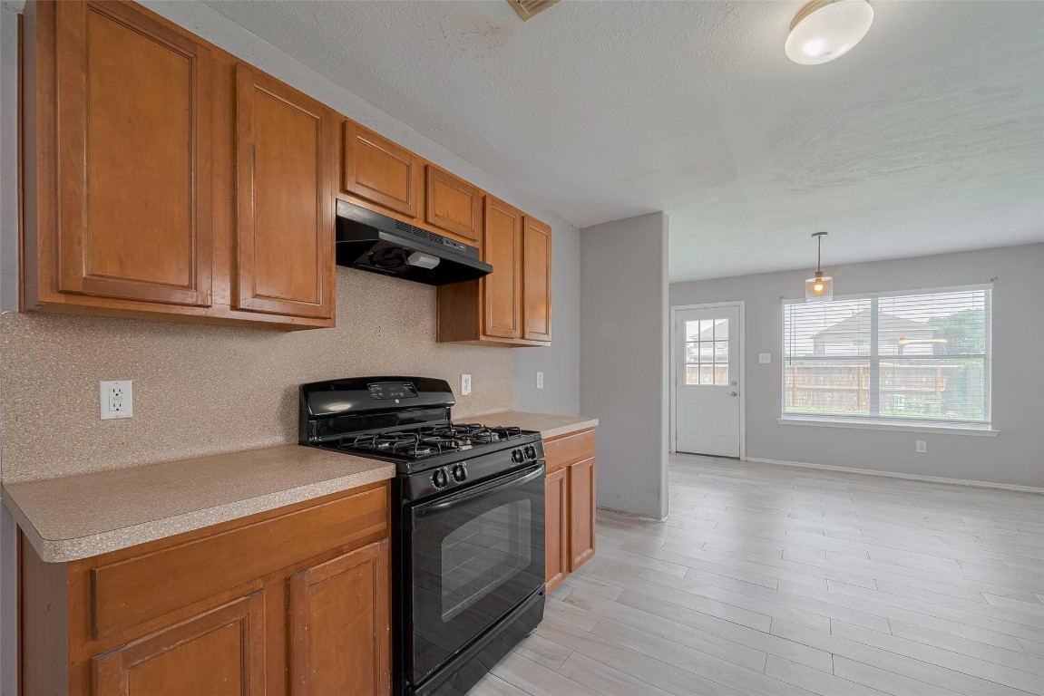 9926 Myrtle Field Lane Houston, TX 77044 - Photo 11 of 33 a kitchen with stainless steel appliances granite countertop a stove a sink and a microwave