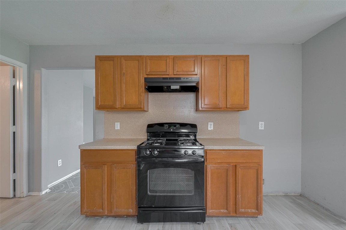 9926 Myrtle Field Lane Houston, TX 77044 - Photo 13 of 33 a kitchen with granite countertop wood cabinets and stainless steel appliances
