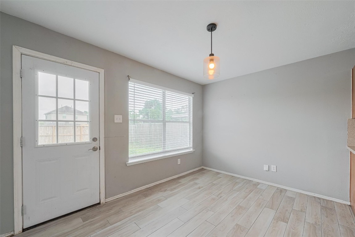 9926 Myrtle Field Lane Houston, TX 77044 - Photo 6 of 33 an empty room with wooden floor and windows