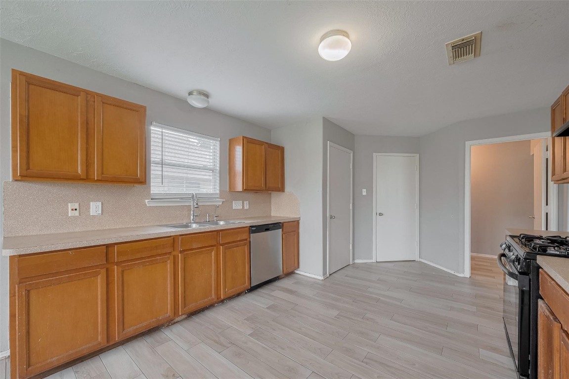 9926 Myrtle Field Lane Houston, TX 77044 - Photo 9 of 33 a view of a kitchen with a sink dishwasher refrigerator and window