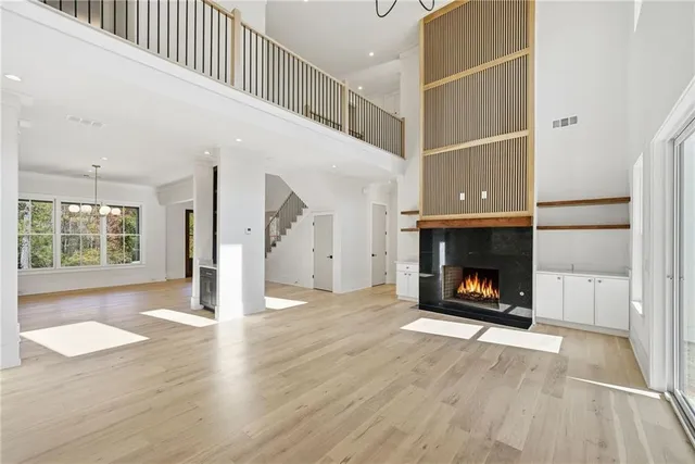 a view of an empty room with wooden floor fireplace and a window