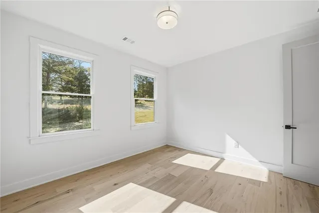 a view of a room with wooden floor and white walls