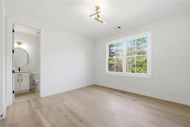 a view of a hallway with wooden floor and a chandelier