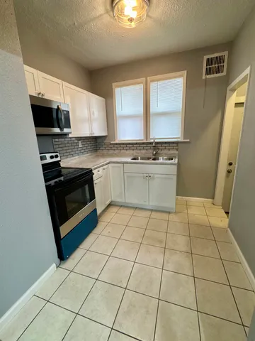 a kitchen with stainless steel appliances granite countertop a stove a sink and a microwave