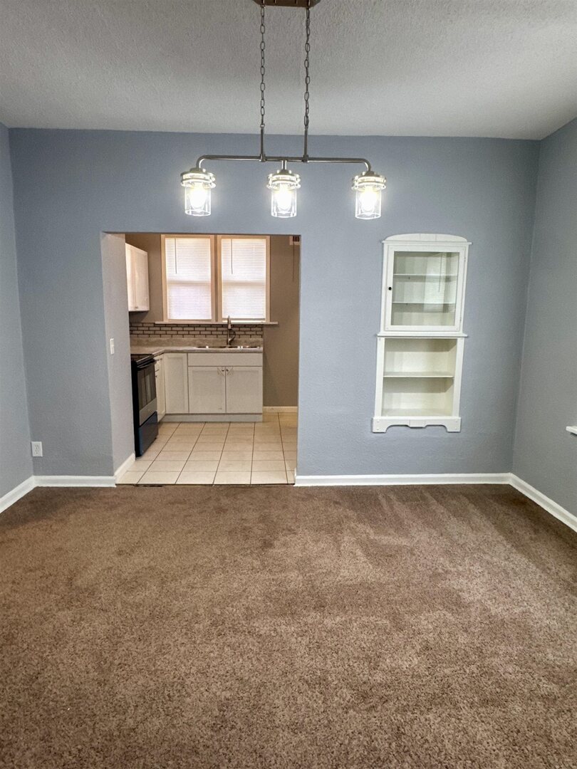 4227 11th Street Rock Island, IL 61201 - Photo 3 of 12 an empty room with chandelier fan and windows