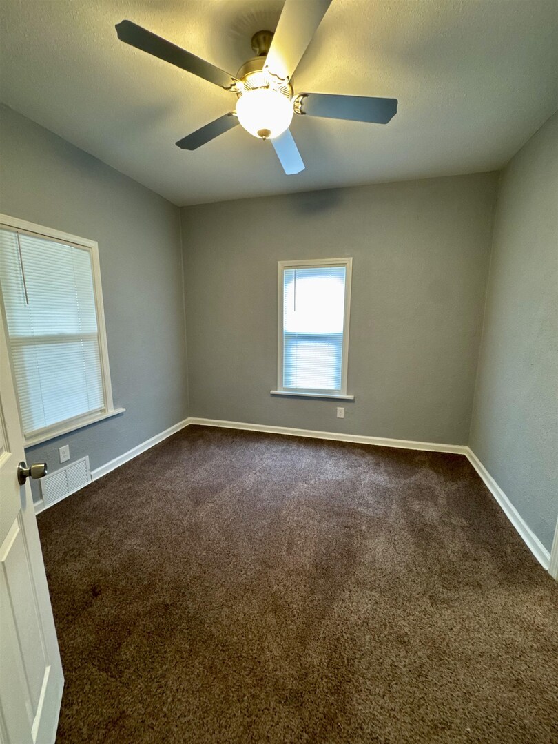4227 11th Street Rock Island, IL 61201 - Photo 8 of 12 an empty room with a window and a fan
