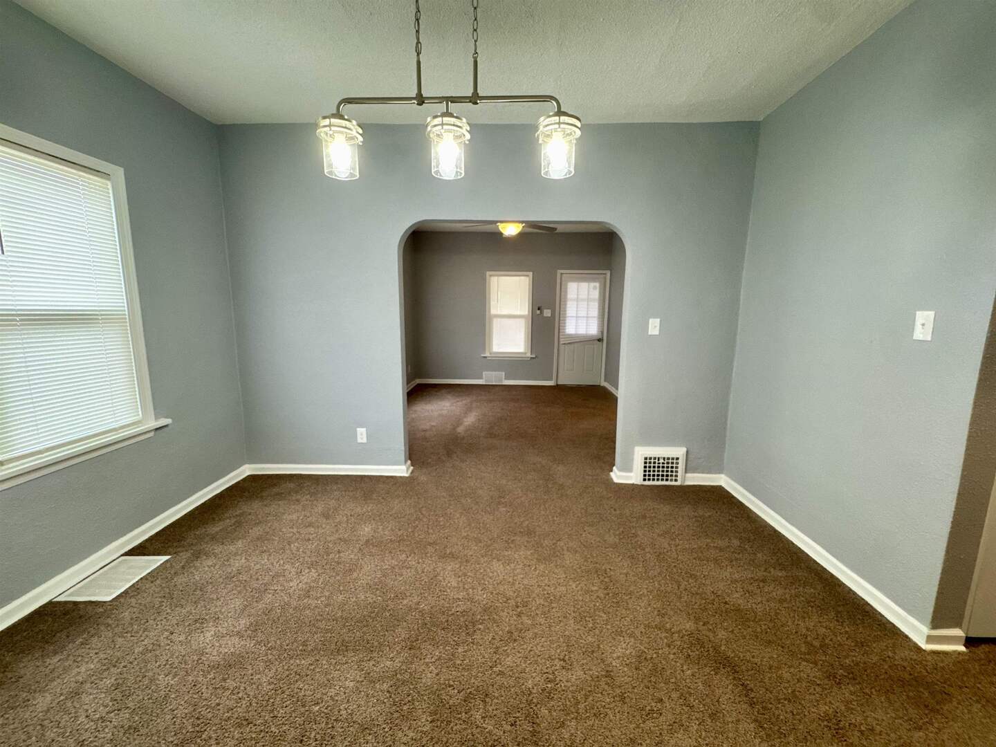 4227 11th Street Rock Island, IL 61201 - Photo 10 of 12 an empty room with a chandelier fan and a window