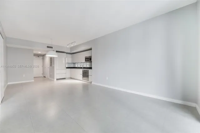 a view of a kitchen with a sink and a refrigerator