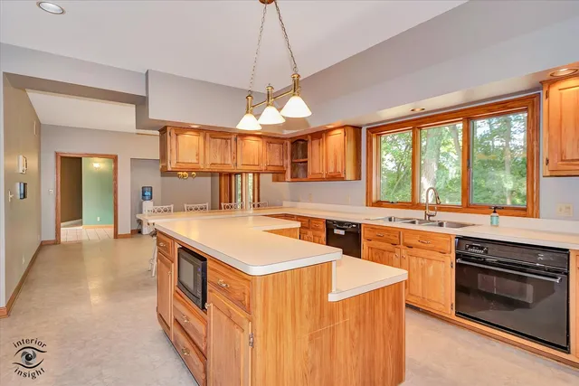 a kitchen with stainless steel appliances granite countertop a stove a sink dishwasher and a refrigerator with wooden floor