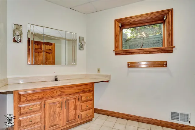 a bathroom with a sink a mirror and a window
