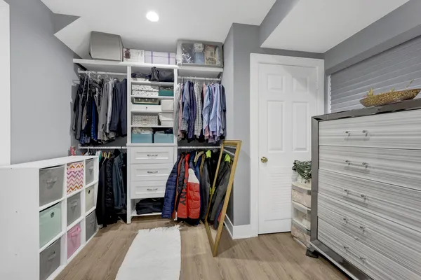 a view of walk in closet with clothes and shoes