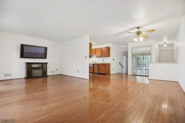 a view of empty room with wooden floor and fireplace