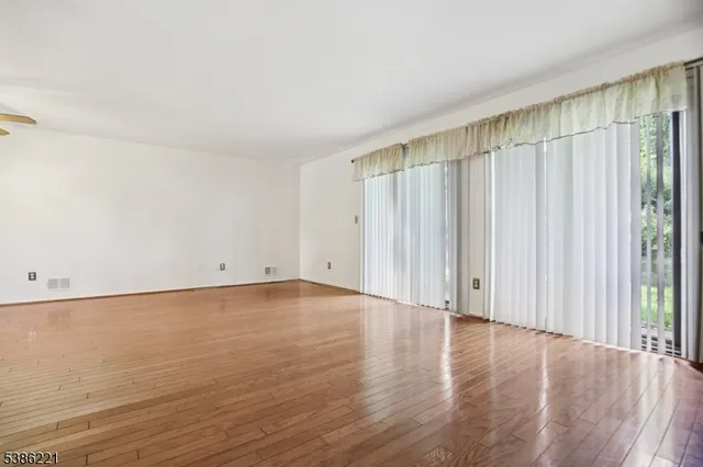 a view of a room with wooden floor and entryway