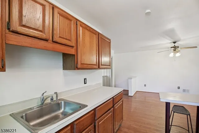 a kitchen with stainless steel appliances granite countertop a sink dishwasher stove and cabinets with wooden floor