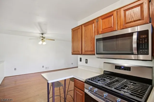 a kitchen with stainless steel appliances granite countertop a stove a microwave cabinets and a sink