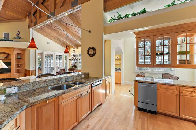 a large kitchen with stainless steel appliances granite countertop a sink and cabinets