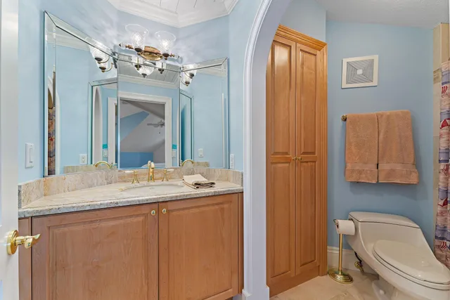 a bathroom with a granite countertop sink toilet and shower