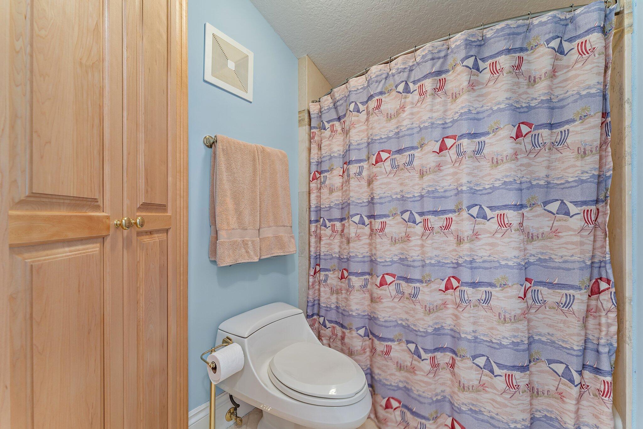134 North Beach Road Hobe Sound, FL 33455 - Photo 33 of 54 a white toilet sitting next to a shower curtain