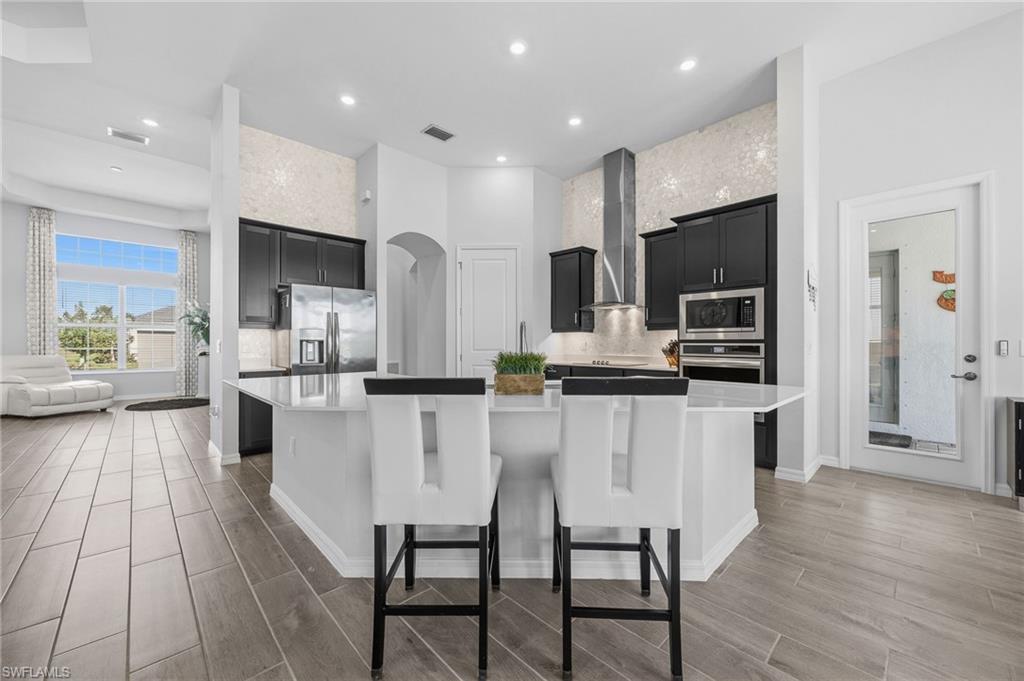 5415 Ternberry Road Ave Maria, FL 34142 - Photo 15 of 45 a kitchen with stainless steel appliances kitchen island granite countertop a refrigerator and microwave