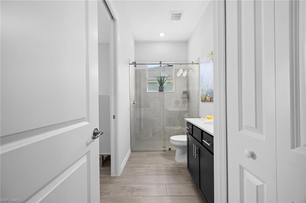 5415 Ternberry Road Ave Maria, FL 34142 - Photo 30 of 45 a bathroom with a granite countertop sink a toilet and shower