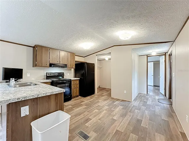 a kitchen with stainless steel appliances granite countertop a refrigerator and a stove top oven