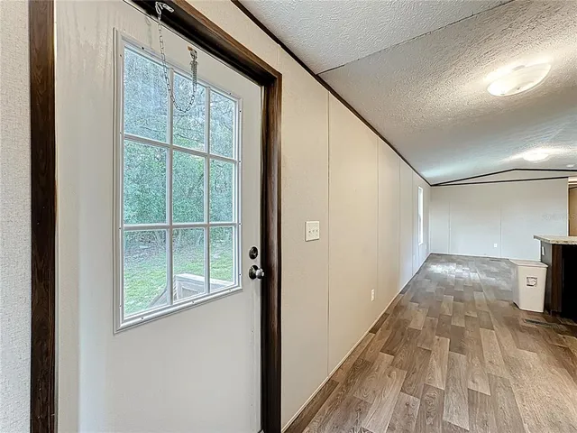 a house that is sitting in a yard with large trees