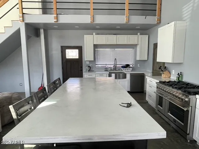 a kitchen with stainless steel appliances a stove a sink and a microwave