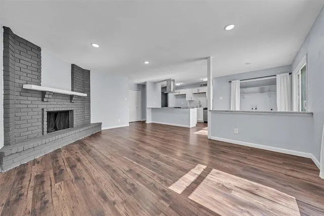 a view of empty room with wooden floor and fireplace