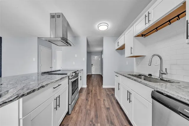 a kitchen with stainless steel appliances granite countertop a sink and stove