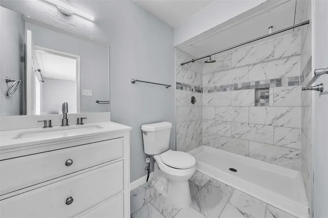 a bathroom with a sink a toilet and shower