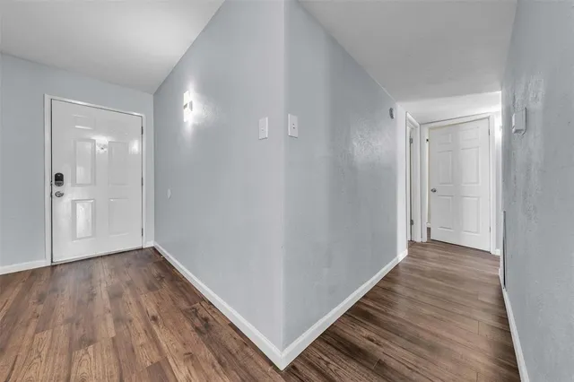 a view of a hallway with wooden floor