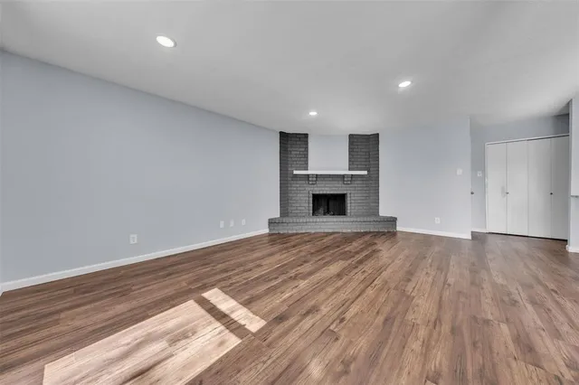 a view of empty room with wooden floor and fireplace