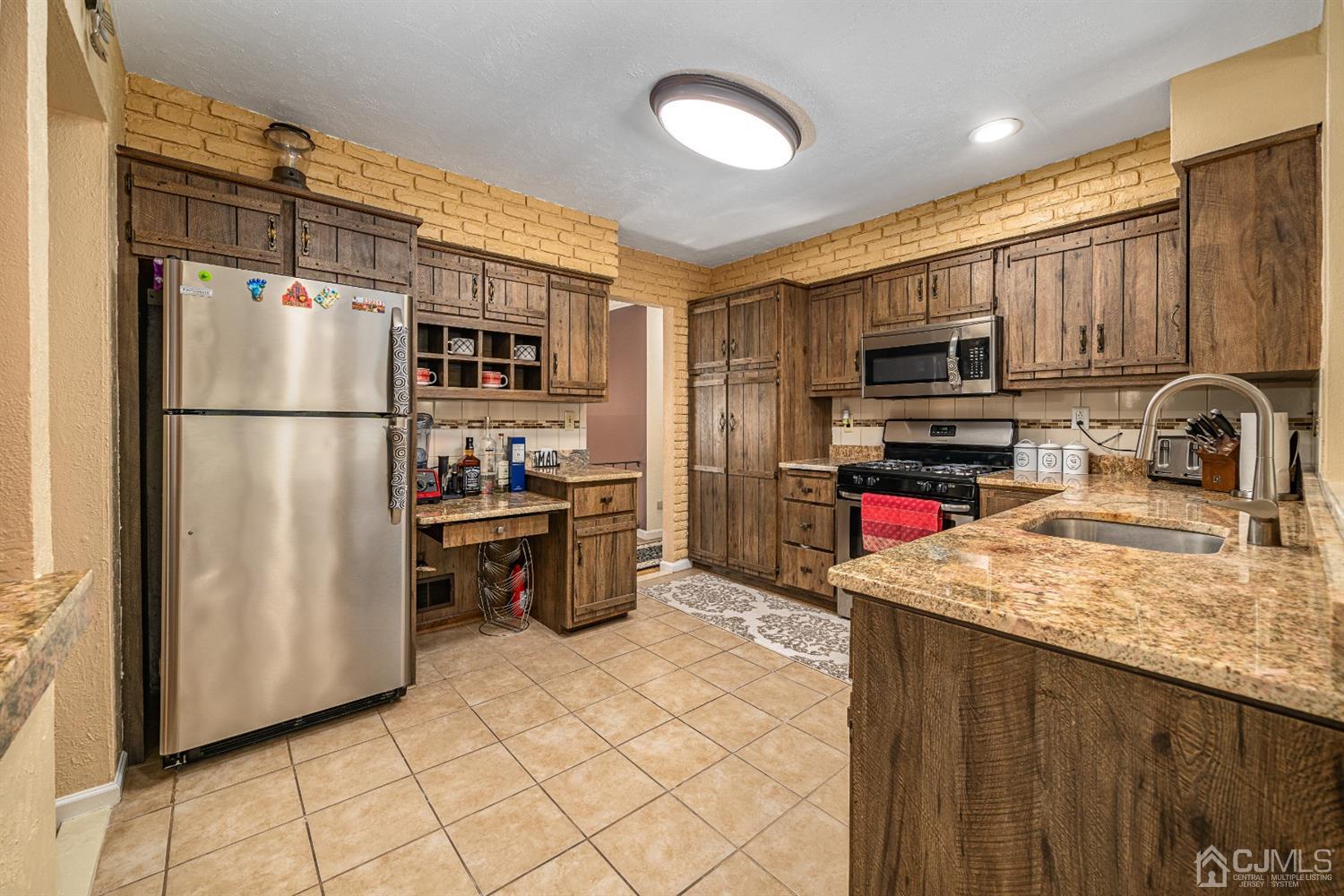16 Hilltop Road Edison, NJ 08820 - Photo 10 of 30 a kitchen with kitchen island granite countertop a refrigerator stove top oven and sink