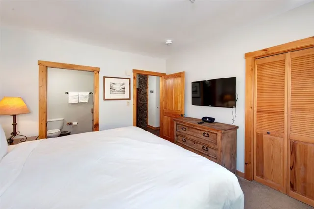 a bedroom with a flat screen tv and a bed