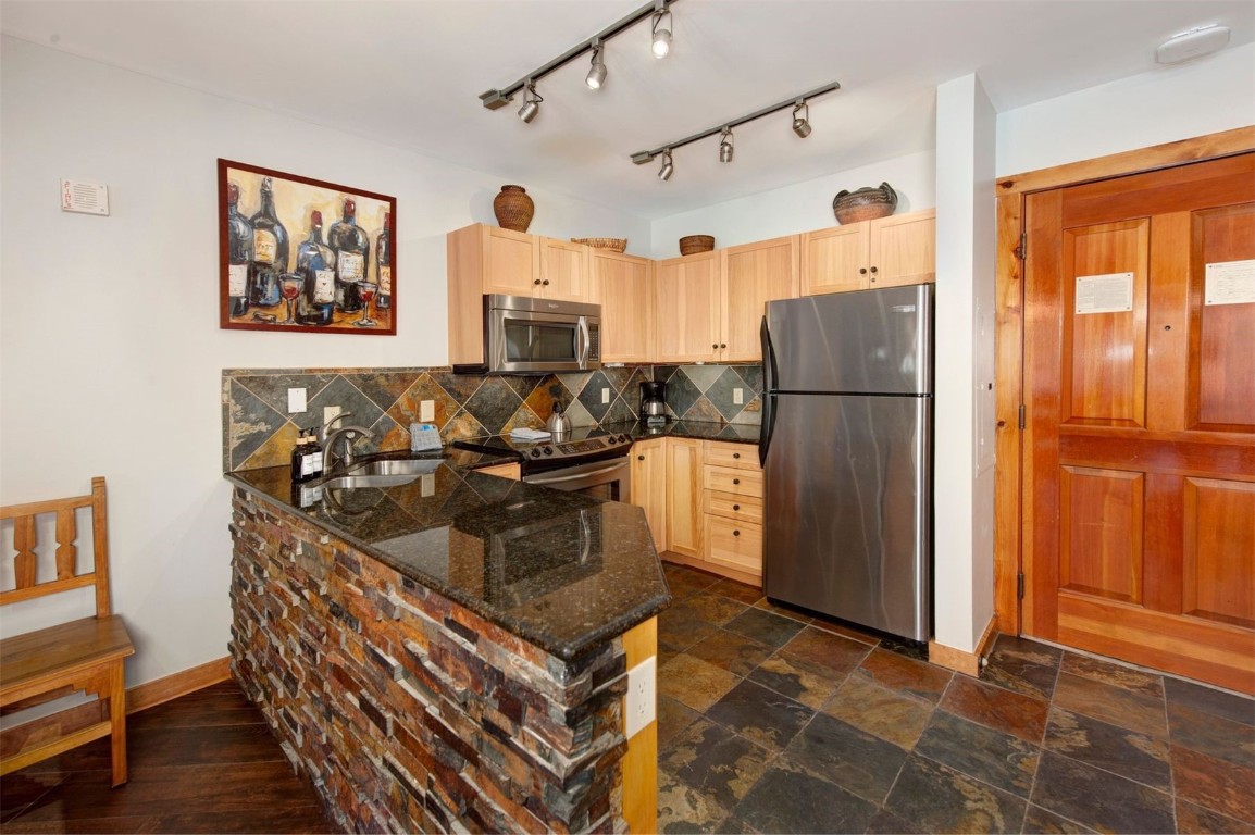 100 Dercum Square, Unit 8362 Keystone, CO 80435 - Photo 9 of 35 a kitchen with stainless steel appliances granite countertop a refrigerator and a stove top oven