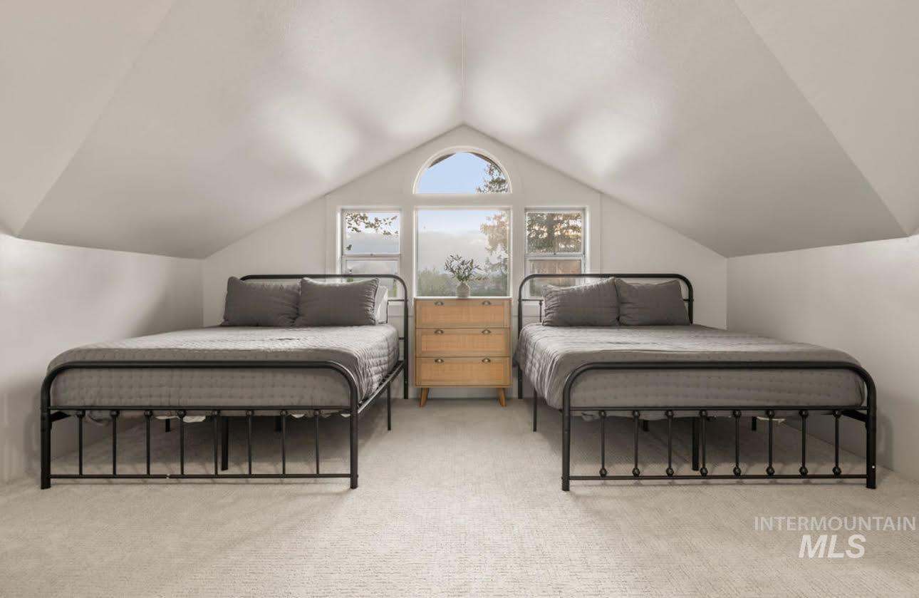 811 Prospect Avenue Lewiston, ID 83501 - Photo 16 of 23 Attic space featuring sloped ceilings, light carpeting, and a central arched window flanked by two rectangular windows