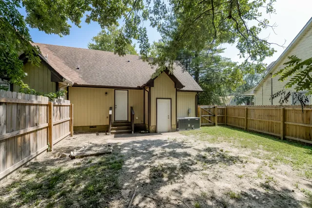 a view of a house with backyard and tree
