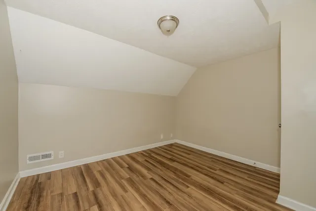a view of a room with wooden floor and white walls
