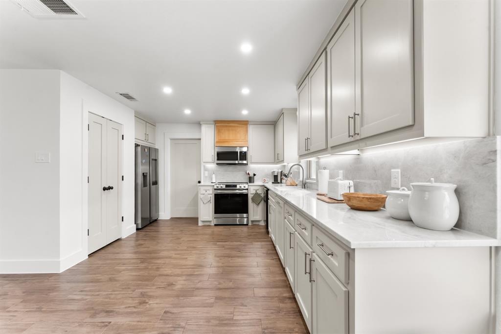 380 Farr Altom Road Seagoville, TX 75159 - Photo 4 of 30 Spacious kitchen featuring light gray cabinetry, stainless steel appliances, wood-finish flooring, recessed lighting, and white countertops