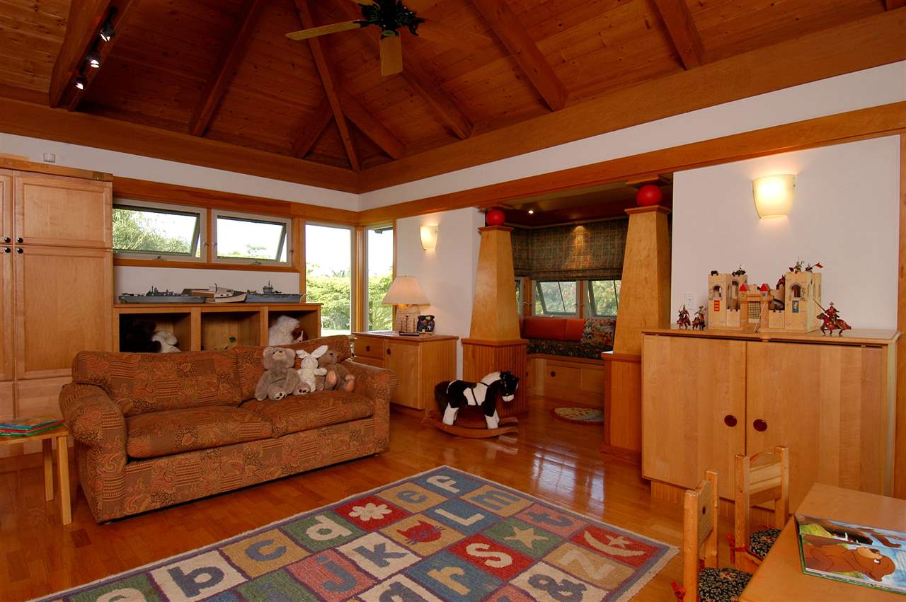 913 Hog Back Road Haiku, HI 96708 - Photo 5 of 18 a living room with furniture a flat screen tv and next to a window