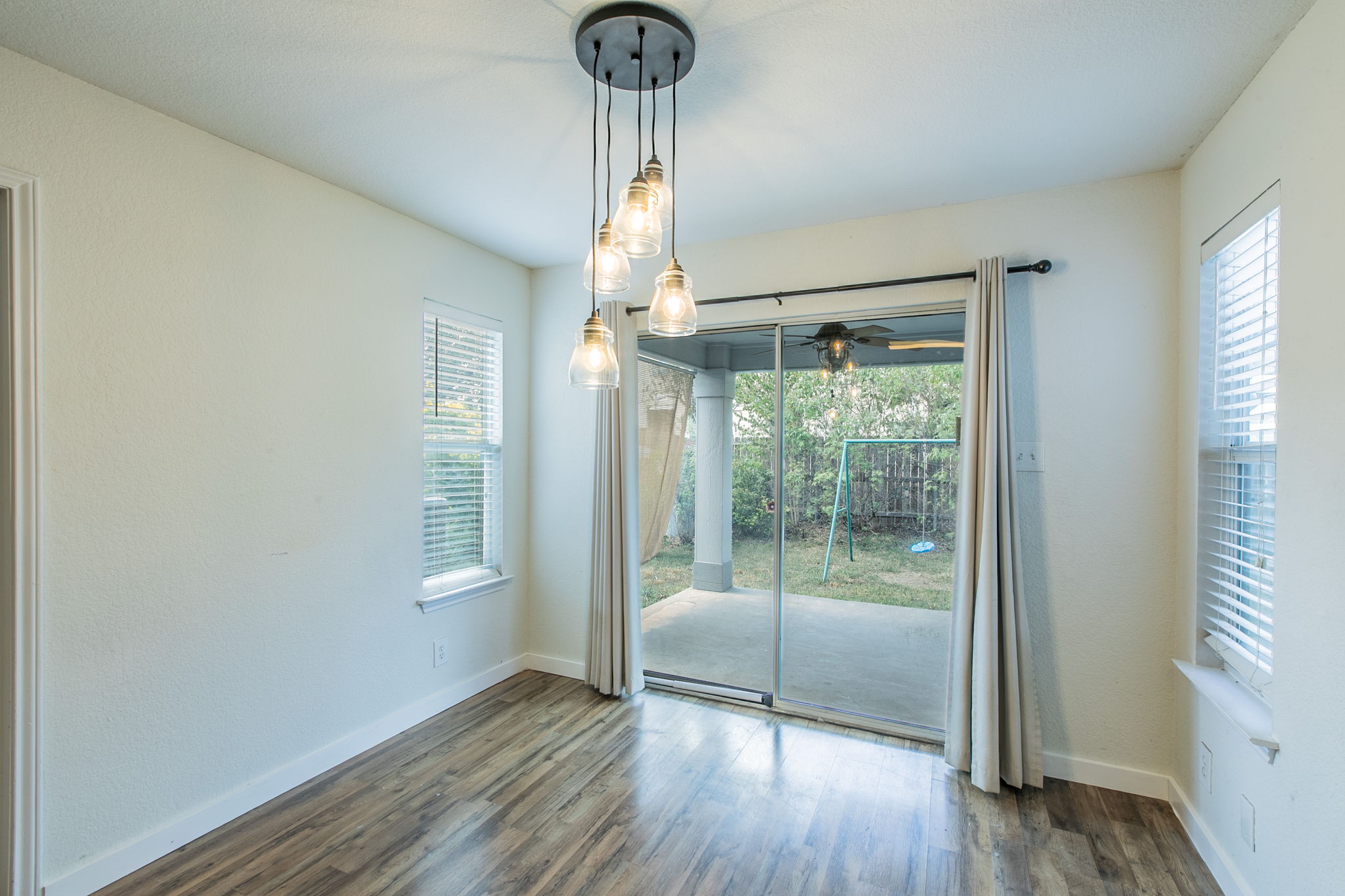 157 Lex Word Kyle, TX 78640 - Photo 10 of 34 Hardwood floors and sliding glass doors create a seamless connection to the backyard patio.