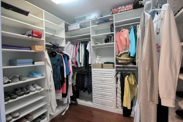 a view of walk in closet with clothes and shoes