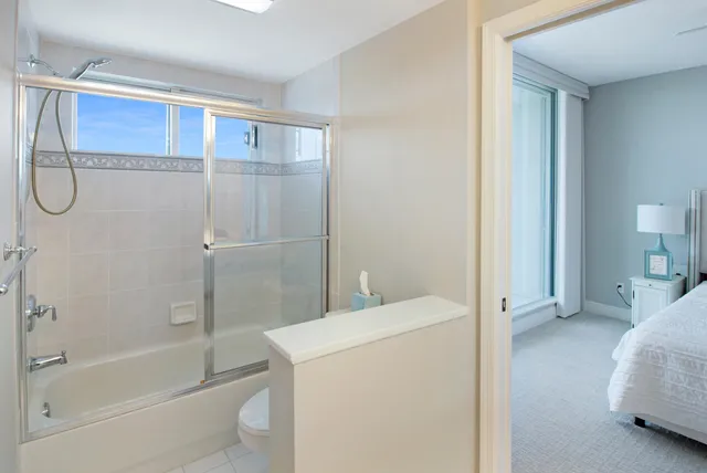 a en suite bathroom with a granite countertop sink a toilet and shower