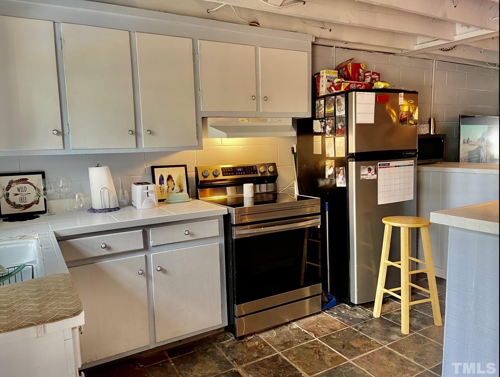 308 Parham Road Henderson, NC 27536 - Photo 14 of 27 a kitchen with stainless steel appliances granite countertop a stove and a refrigerator