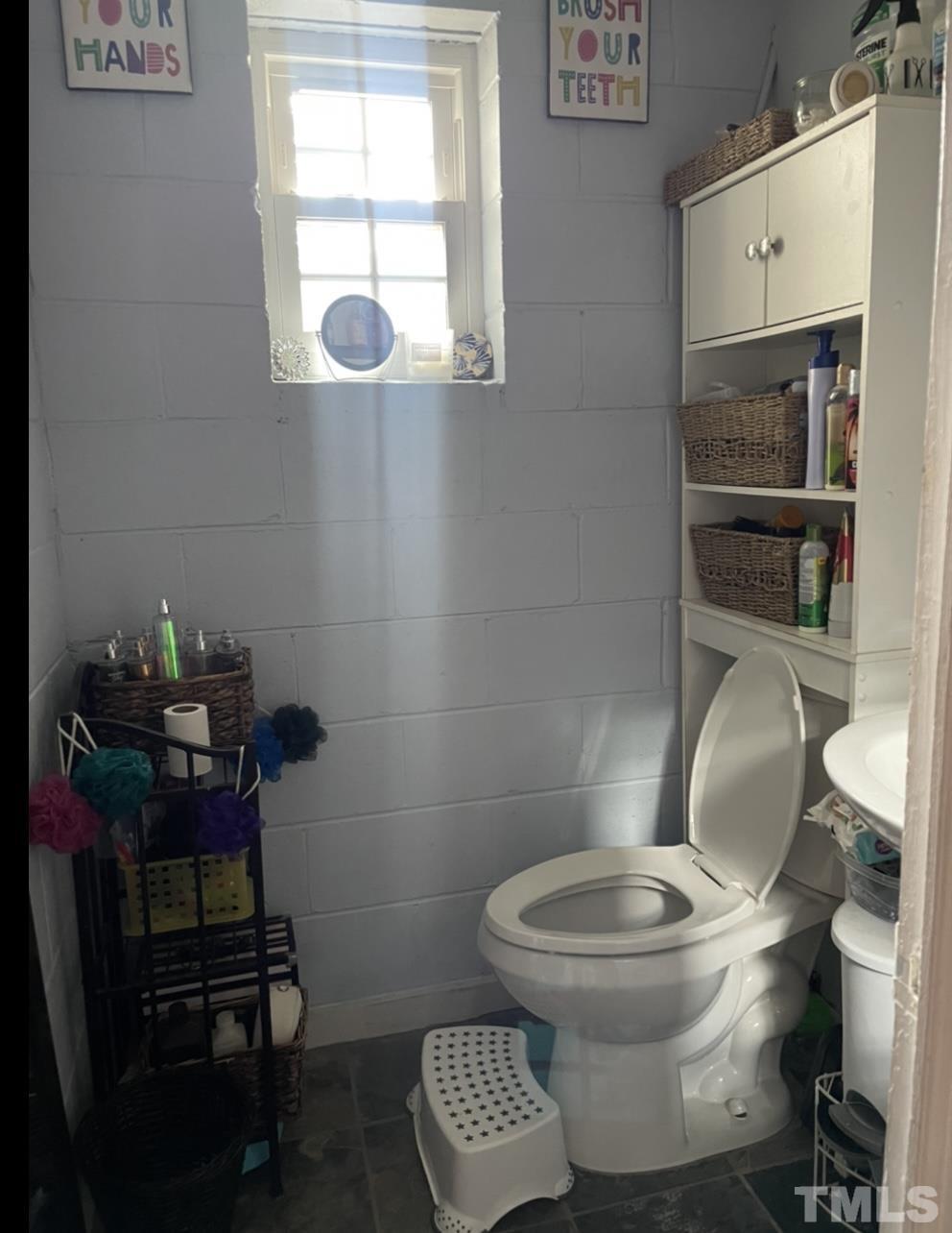 308 Parham Road Henderson, NC 27536 - Photo 17 of 27 a bathroom with a toilet a sink and a window