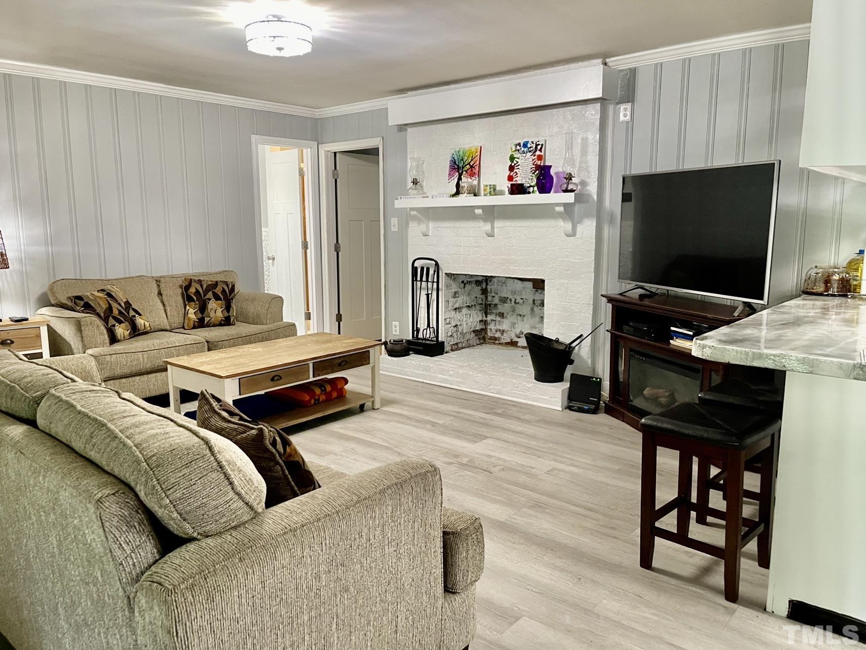 308 Parham Road Henderson, NC 27536 - Photo 6 of 27 a living room with furniture and a flat screen tv with kitchen view