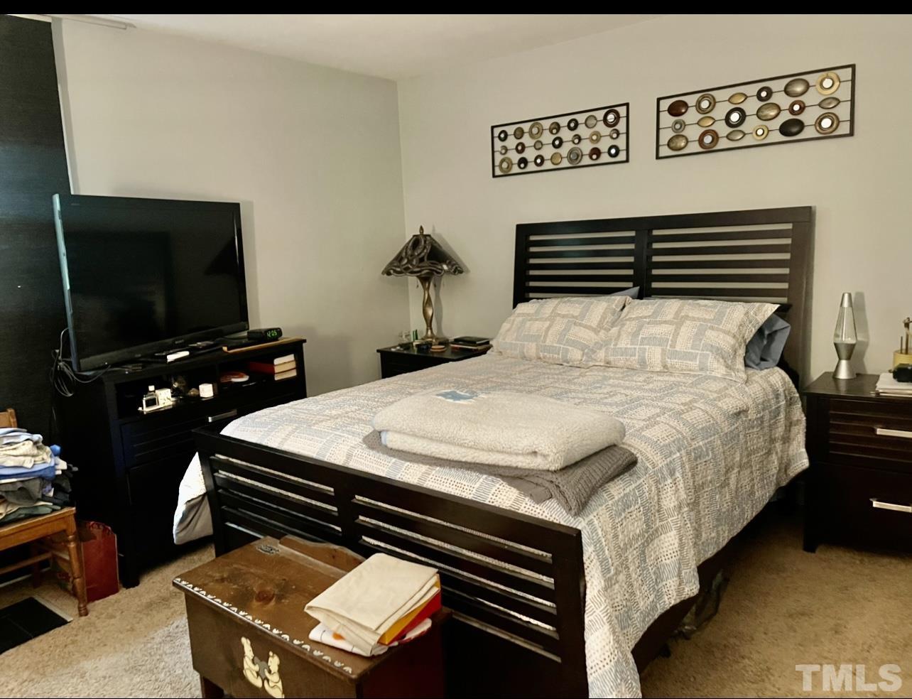 308 Parham Road Henderson, NC 27536 - Photo 9 of 27 a bedroom with a bed and a flat screen tv