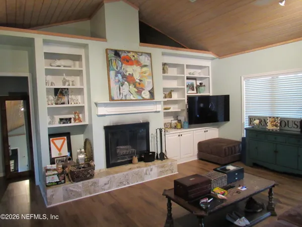 a living room with furniture a fireplace and a flat screen tv
